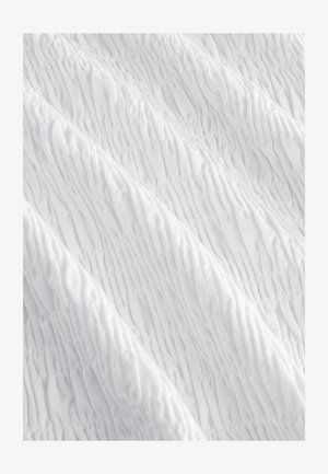 Biała tkanina z teksturowanym, marszczonym wzorem, zawierającym pionowe marszczenia i delikatne fale, tworząca miękki i lekkawy wygląd.