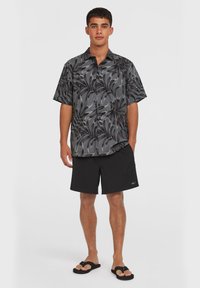 Short-sleeve shirt in black and gray floral pattern, paired with black shorts and flip-flops. Shirt features a button-up design.