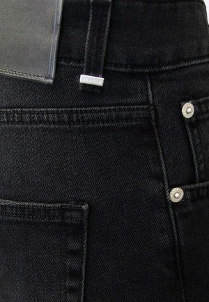 Jeans in denim nero con vita alta, cuciture visibili, due tasche posteriori e accenti in metallo. Etichetta piatta in pelle attaccata.