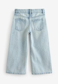 Ljusblå denimjeans med vida ben, med medelhög midja, två bakfickor och rå kant. Materialet är mjukt med en urtvättad yta.