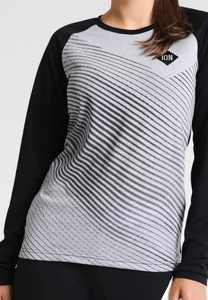 Kobieta w długim rękawie czarno-szarej koszulce kolarskiej z ukośnymi czarnymi paskami i małym logo "ION" na piersi.