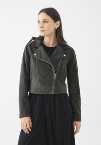 Chaqueta de moto cropped de ante gris oscuro con cuello de muesca, herrajes plateados y bolsillos frontales con cremallera. Mangas largas, textura suave.