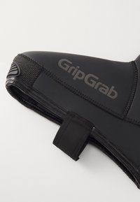 Melnā neoprene apava ar strukturētu gripējošo zoli, uzdrukātu "GripGrab" logo un pirkstu aizsargu dizainu, kas nodrošina uzlabotu kāju aizsardzību un stabilitāti.