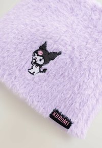 Fioletowa torba z sztucznego futra z haftowanym motywem postaci w czarnym kapeluszu i różowymi akcentami. Zawiera czarną metkę z napisem "KUROMI."