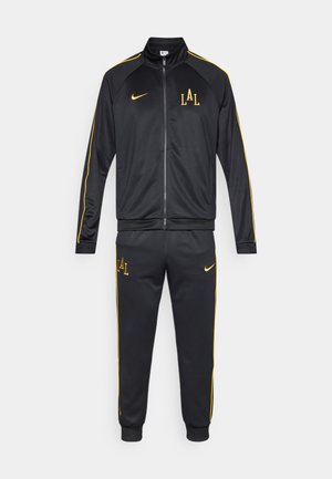 Black tracksuit made of polyester, featuring a zip-up jacket and elastic waist pants, accented with yellow stripe and logo details.
