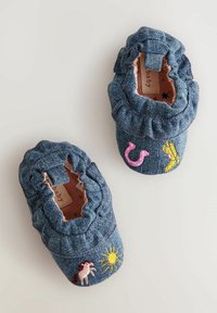 Zapatos de bebé de denim con bordes de volantes elásticos, que presentan diseños bordados de sol, caballo, flamenco y plátano sobre un fondo azul.