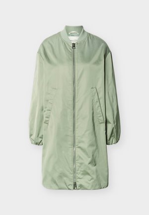 Veste bomber longue vert clair avec fermeture éclair à l'avant, col côtelé, poignets élastiques et deux poches latérales inclinées, présentée sur un fond blanc.