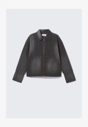 Zwarte denimjas met een rits aan de voorkant, een puntige kraag en twee voorzakken. Licht vervaagde textuur en lange mouwen.
