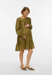 Oliveiroheline raseduskleit pikkade põlvikvarrukatega, volangilise kaelusega ja kihilise äärega. Kerge kangas suurendab mugavust. Komplektis terava ninaga madalad kingad.