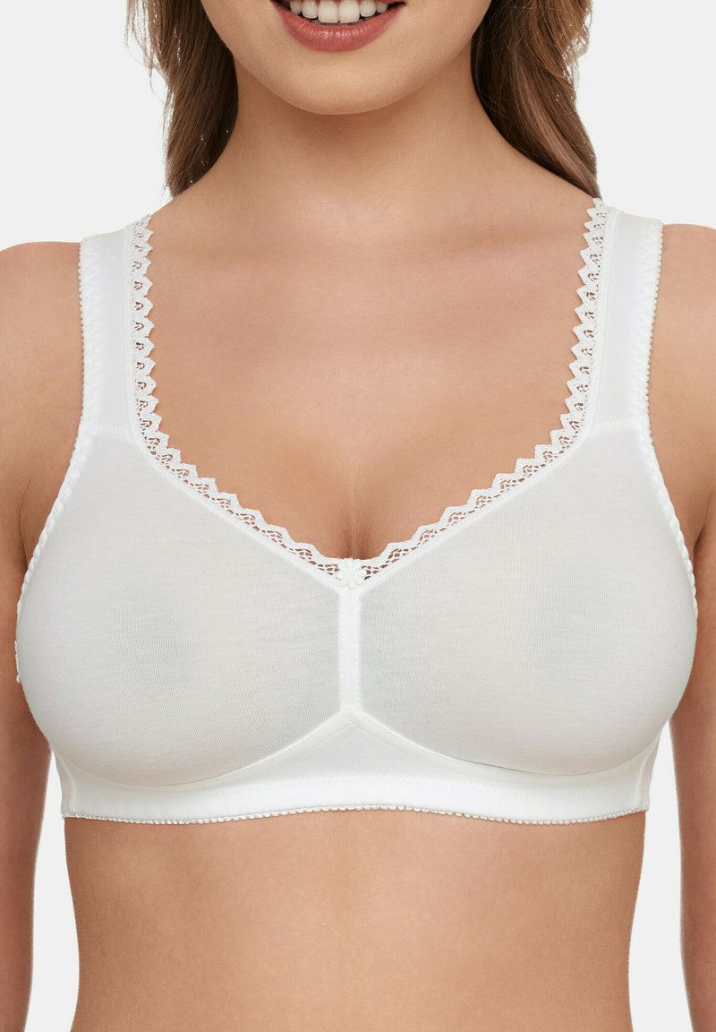 Weißer wireless BH mit glatter Textur, V-Ausschnitt-Design, dekorativem gewellten Saum an den Trägern und einem floralen Akzent in der Mitte vorne.