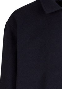 Svart ullblandad kappa med krage, med en mjuk textur och avslappnad passform. Sömmen är minimal, vilket betonar den eleganta designen.