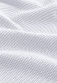 Tissu blanc texturé avec de fines nervures subtiles, présentant un aspect doux et une surface lisse ; idéal pour les vêtements ou la tapisserie.