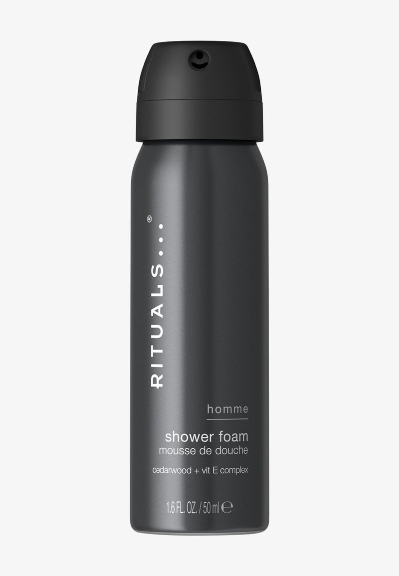 Boîte cylindrique noire de mousse de douche Rituals Homme avec bouchon noir, étiquetée bois de cèdre et complexe vitamine E, volume 50 ml.