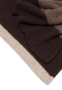 Braune und beige Wolldecke mit strukturierter Oberfläche, die entlang des Randes einen Verlauf von Dunkelbraun zu Hellbeige aufweist.