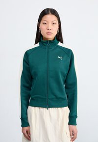 Giacca a track verde realizzata in tessuto liscio, con pannelli laterali crema, colletto alto, zip completa e piccolo logo bianco sul lato sinistro del petto.
