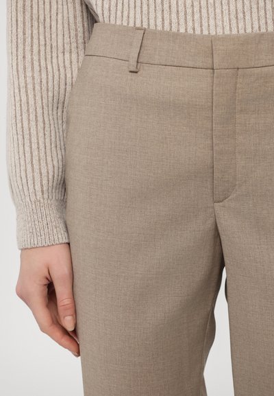 Beige suorat housut, joissa on sileä pinta, hienovarainen kudos ja sivusaumapocketit, yhdistettynä vaaleaan ribbipaitaan.