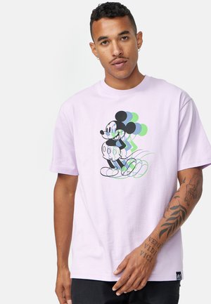 T-shirt di cotone lilla con grafica di un personaggio con palloncini in tonalità nere e verdi, maniche corte e una vestibilità morbida.