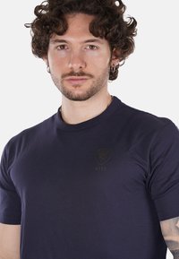 T-shirt a maniche corte blu navy realizzato in morbido cotone, con un discreto logo NYPD sul petto e un classico collo a giro.