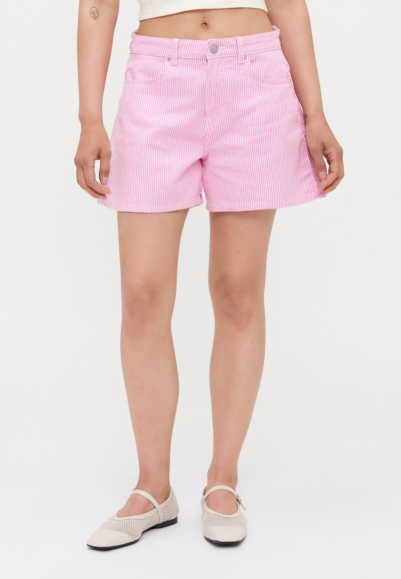 Bermudas de mezclilla a rayas rosas y blancas con una cintura de altura media, bolsillos frontales y detalles de metal plateado en la cinta del cinturón.