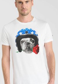 Camiseta blanca con un gráfico de un bulldog con un casco azul con estrellas blancas, sosteniendo una rosa roja en la boca.