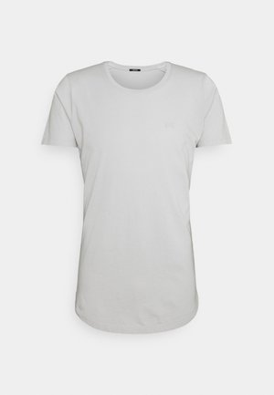 T-shirt uni gris clair à manches courtes et col rond avec un petit logo subtil sur la poitrine gauche, présenté sur fond blanc.