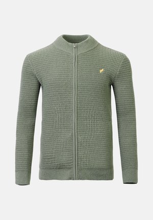 Grønn strikket cardigan med glidelås, høy krage og teksturert mønster. Har gul logo aksent på venstre bryst.