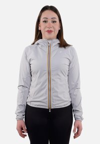 Giacca con zip grigia chiara con cappuccio, caratterizzata da una zip colorata e polsini elastici, realizzata in un materiale morbido e leggero.