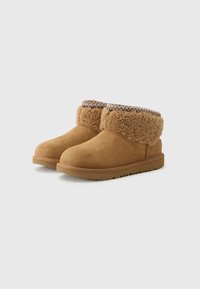 Bottines en daim marron avec un col en shearling doux et une bordure tissée décorative, dotées d'une semelle texturée pour une bonne adhérence et du confort.