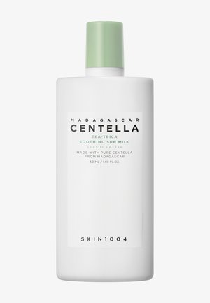 Weiße Plastikflasche mit hellgrünem Verschluss, beschriftet mit "Madagascar Centella Tea-Trica Soothing Sun Milk SPF50 PA++++", 50 ml.
