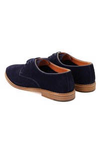 Chaussures en daim bleu marine avec un bout arrondi, semelle en caoutchouc brun et doublure contrastante en beige. Design à lacets avec des accents cousus sur le dessus.