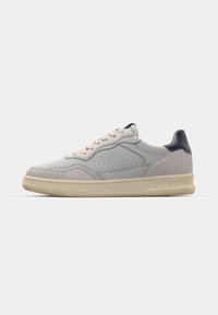 Adidași gri deschis din materiale de piele și suede, cu talpă intermediară bej și accente bleumarin. Prezintă detalii perforate pe părțile laterale și branding pe toc.