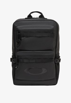 Sac à dos rectangulaire noir avec deux poches avant zippées, poches latérales en mesh, bretelles réglables et une poignée en boucle sur le dessus.