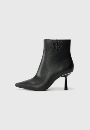 Black leather ankle boot with a pointed toe, textured finish, and a slender heel. Features embossed DKNY logo on the back.