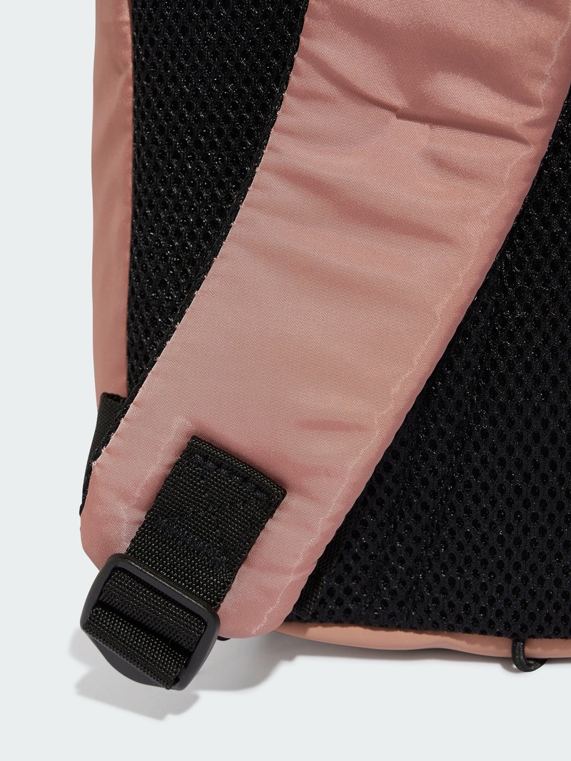 Rosa Nylon-Rucksack-Ecke mit schwarzem Netzpanel, ausgestattet mit einem schwarzen Kunststoffverschluss und strukturiertem Stoff. Glatte Oberfläche mit kontrastierenden Farben.