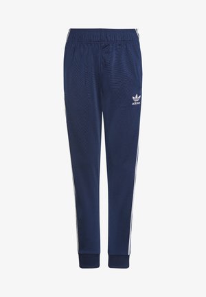 Pantalon de survêtement Adidas bleu marine avec ceinture élastique, bandes blanches sur les côtés, poignets côtelés et logo Trefoil Adidas sur la cuisse gauche.