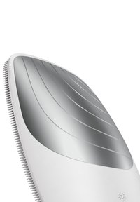 Elektrisk hårborste med en vit plastkropp, kurvad ergonomisk form, silverborstad metalltop med ribbor och mjuka borst längs kanten.