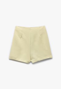 Pantalones cortos ajustados amarillo claro con una textura suave, que presentan dos pliegues frontales, un dobladillo recto y sin cierres visibles.