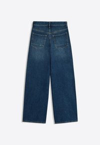 Jean en denim bleu foncé à jambes larges vu de dos avec deux grandes poches carrées à l'arrière et des passants pour ceinture à la taille.