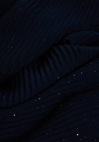 Tela azul marino con textura acanalada, con detalles dorados brillantes dispersos, creando una apariencia en capas y contrastante.