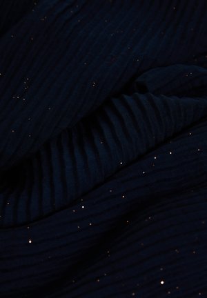 Tissu bleu marine à texture côtelée, orné de détails scintillants dorés dispersés, créant un aspect superposé et contrasté.