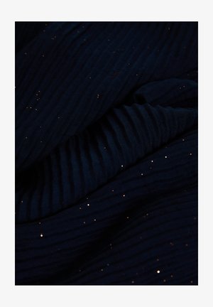 Tissu bleu marine à texture côtelée, orné de détails scintillants dorés dispersés, créant un aspect superposé et contrasté.