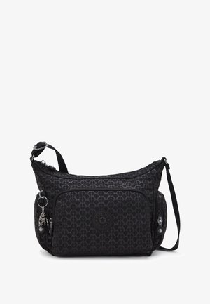 Black nylon shoulder bag with geometric pattern, adjustable strap, front pocket, and metal charm detail. Features zipper closures and logo patch.