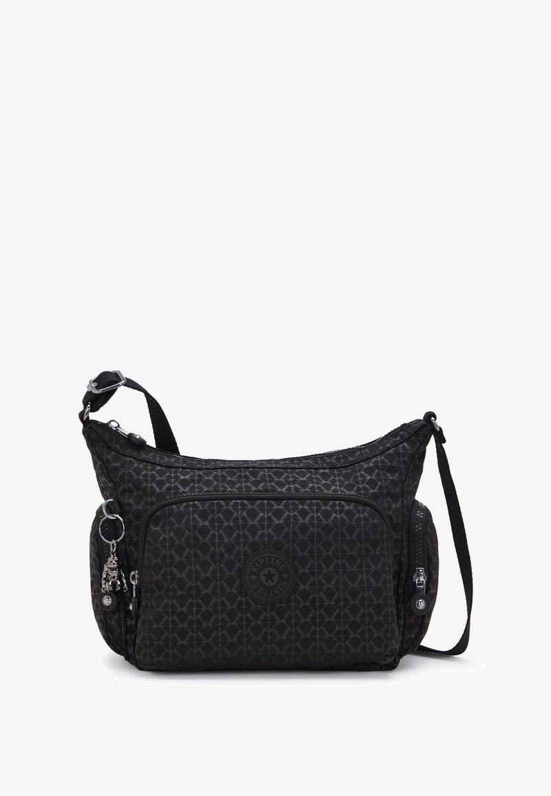 Black nylon shoulder bag with geometric pattern, adjustable strap, front pocket, and metal charm detail. Features zipper closures and logo patch.