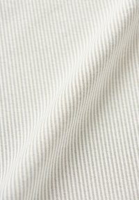 Tessuto con strisce sottili bianche e grigie alternate, texture morbida, superficie liscia e una leggera lucentezza. Ideale per tappezzeria o abbigliamento.