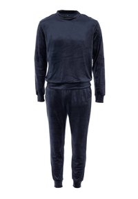 Tuta in velluto blu navy con maglia a maniche lunghe e colletto rotondo, abbinata a pantaloni tapered. Textura morbida e polsini elasticizzati.