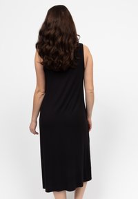 Schwarzes, ärmelloses Midikleid mit einem schlichten, taillierten Design und glatter Textur, ausgestattet mit einem runden Rücken und fließendem Saum.
