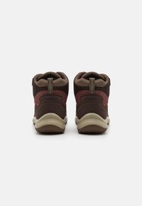 Braune Wanderschuhe mit Mesh-Akzenten, gepolsterten Kragen, Zuglaschen und einer weißen Gummisohle; mit einem kontrastierenden maronenfarbenen Einsatz an der Rückseite.