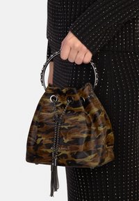 Torba wiaderkowa w kamuflażowy wzór, wykonana z brązowego i zielonego zamszu, z zamknięciem na sznurek, srebrnymi okuciami i ozdobnym chwostem. Okrągły metalowy uchwyt.