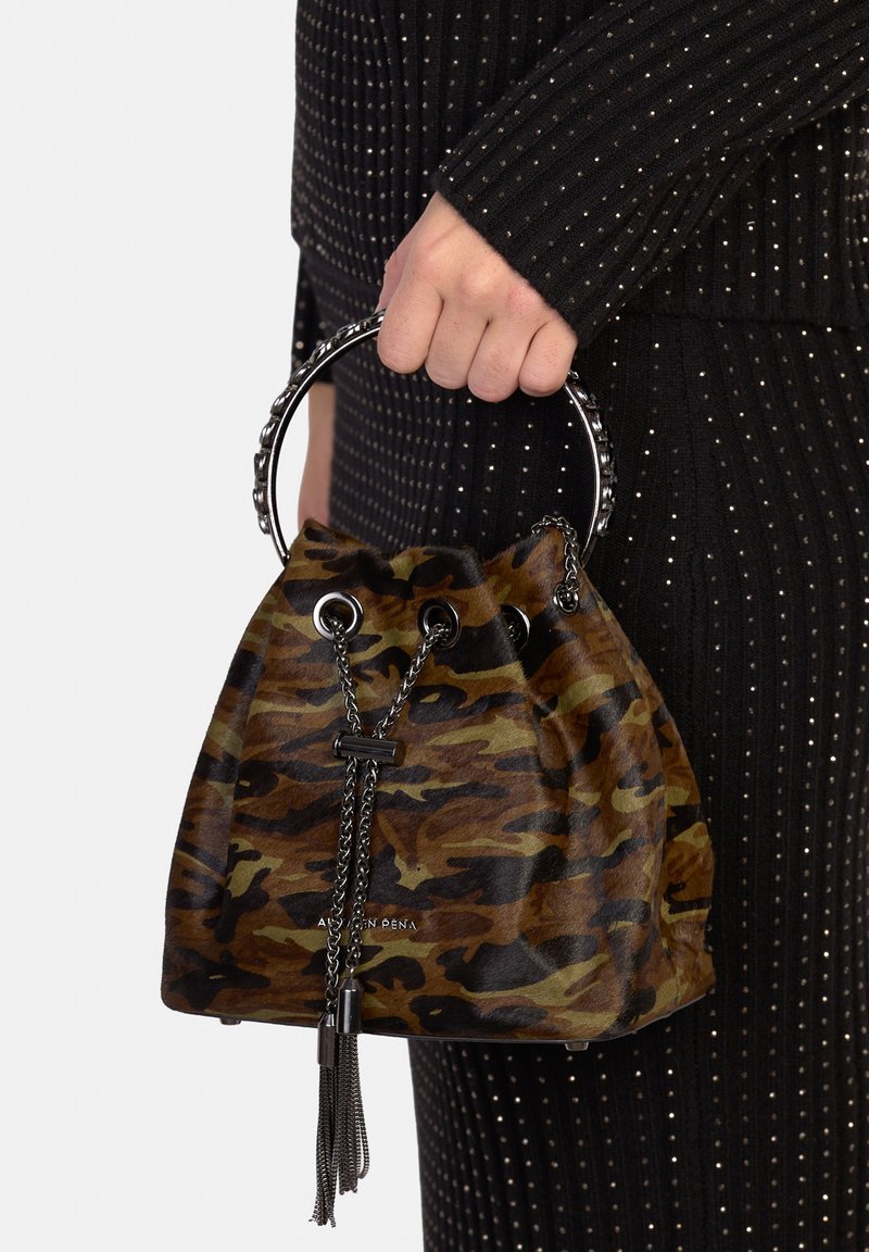 Torba wiaderkowa w kamuflażowy wzór, wykonana z brązowego i zielonego zamszu, z zamknięciem na sznurek, srebrnymi okuciami i ozdobnym chwostem. Okrągły metalowy uchwyt.