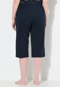Navyblauwe capri-broeken met een elastische tailleband, een gladde textuur en een aansluitend ontwerp dat net onder de knie valt.